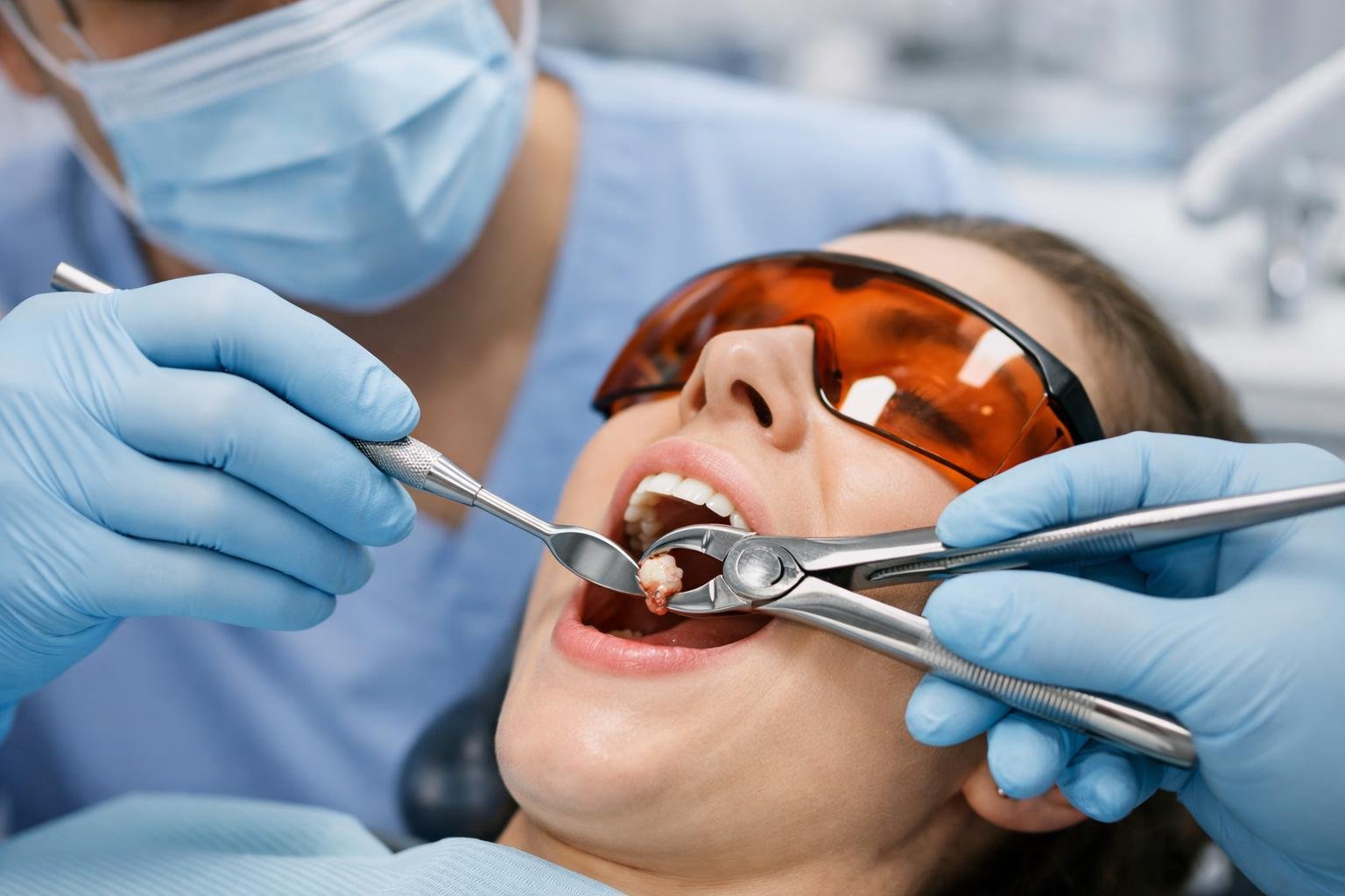 Dentist performing a tooth extraction on a patient in a dental clinic using dental instruments.